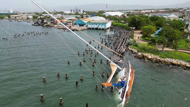 A boat damaged by Hurricane Beryl lays on its side at a dock in Kingston, Jamaica, Thursday, July 4, 2024. (AP Photo/Leo Hudson)