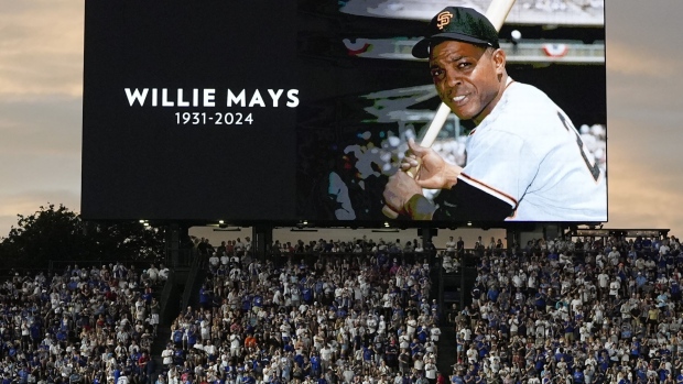 Fans stand for a moment of silence for former MLB player Willie Mays during the sixth inning of a baseball game between the San Francisco Giants and the Chicago Cubs in Chicago, Tuesday, June 18, 2024. (AP Photo/Nam Y. Huh)