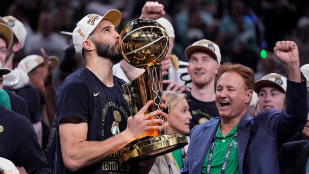 Boston Celtics forward Jayson Tatum kisses the Larry O'Brien Championship Trophy after Game 5 of the NBA Finals basketball series against the Dallas Mavericks. (Charles Krupa/AP)